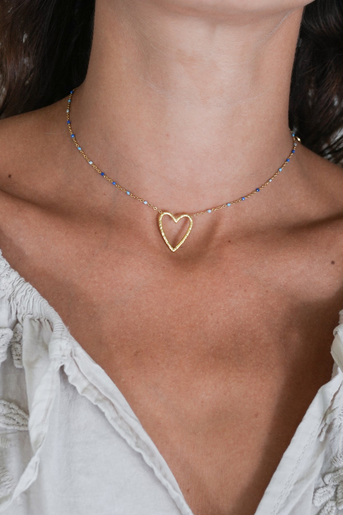 Necklace with a heart pendant worn by a person