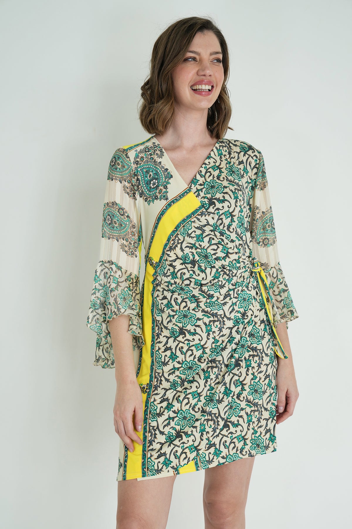 Woman wearing a floral dress with yellow accents on a white background
