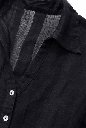 Close-up of a black button-front shirt with a pointed collar and visible textured inner lining.
