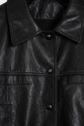 Close-up of a black leather jacket with buttons