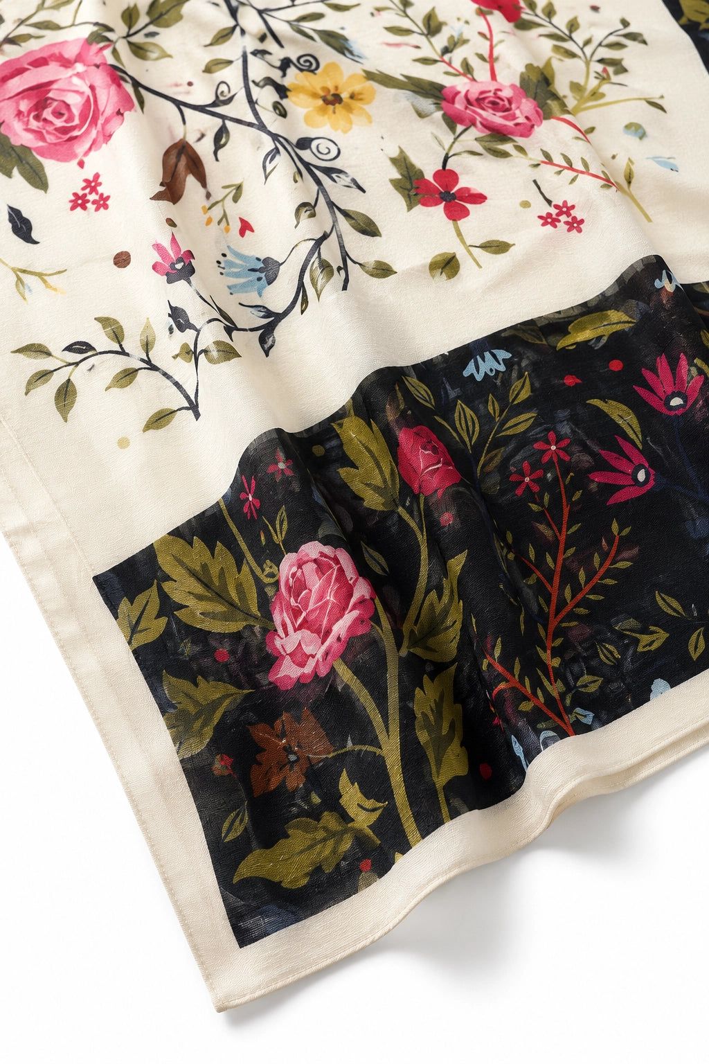 A close-up of a printed fabric with a cream base and a large black panel featuring pink roses, green leaves, and floral motifs.