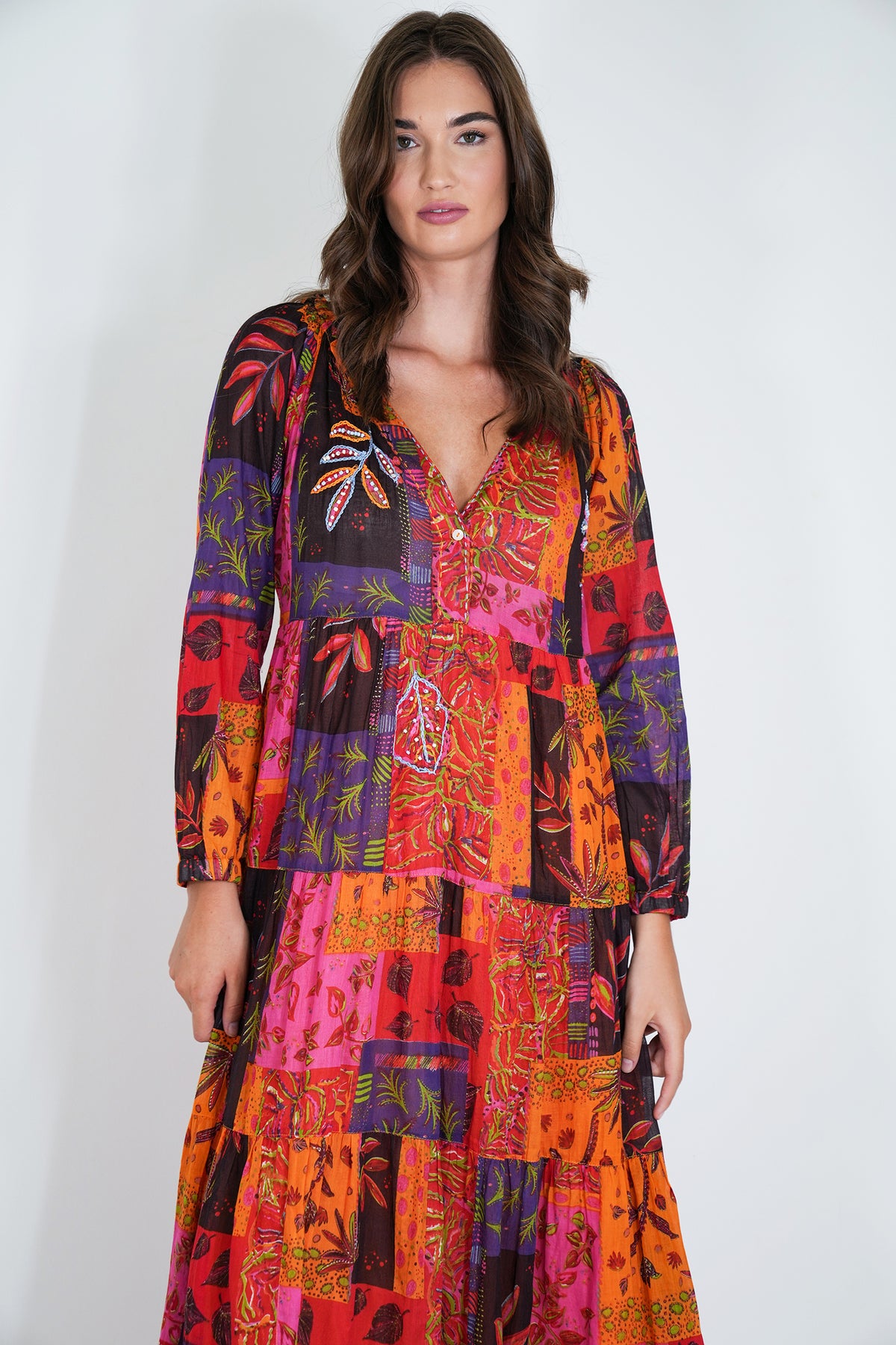 Woman wearing a colorful patterned dress on a white background