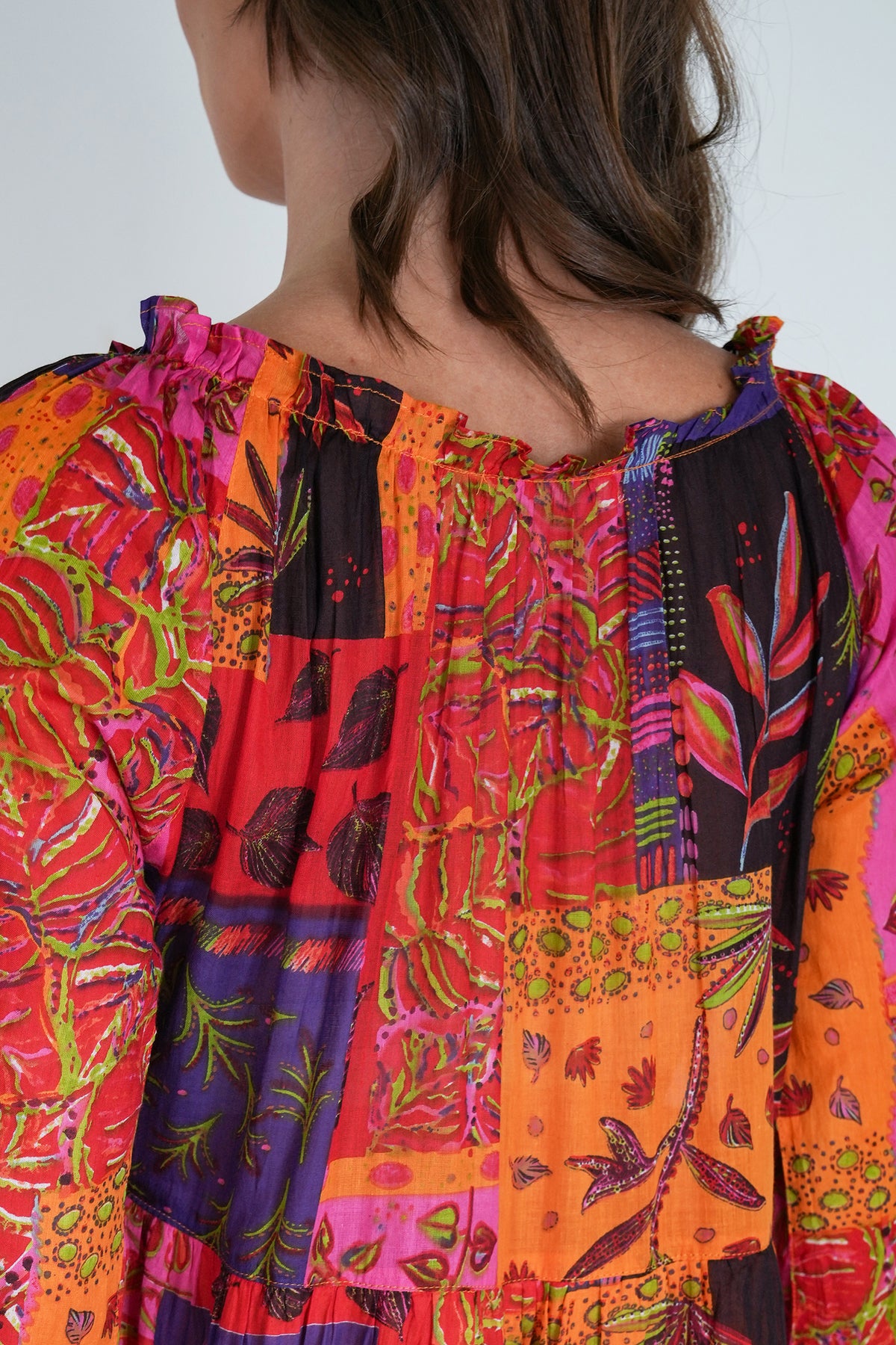 Colorful patchwork dress with floral patterns on a plain background