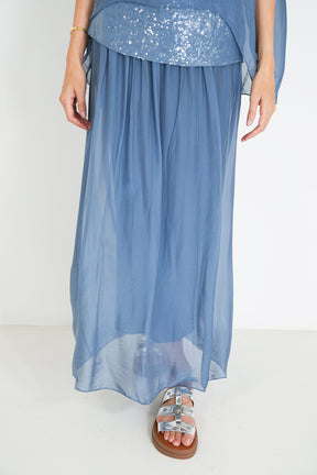 Blue silk dress with sequin top on a white background