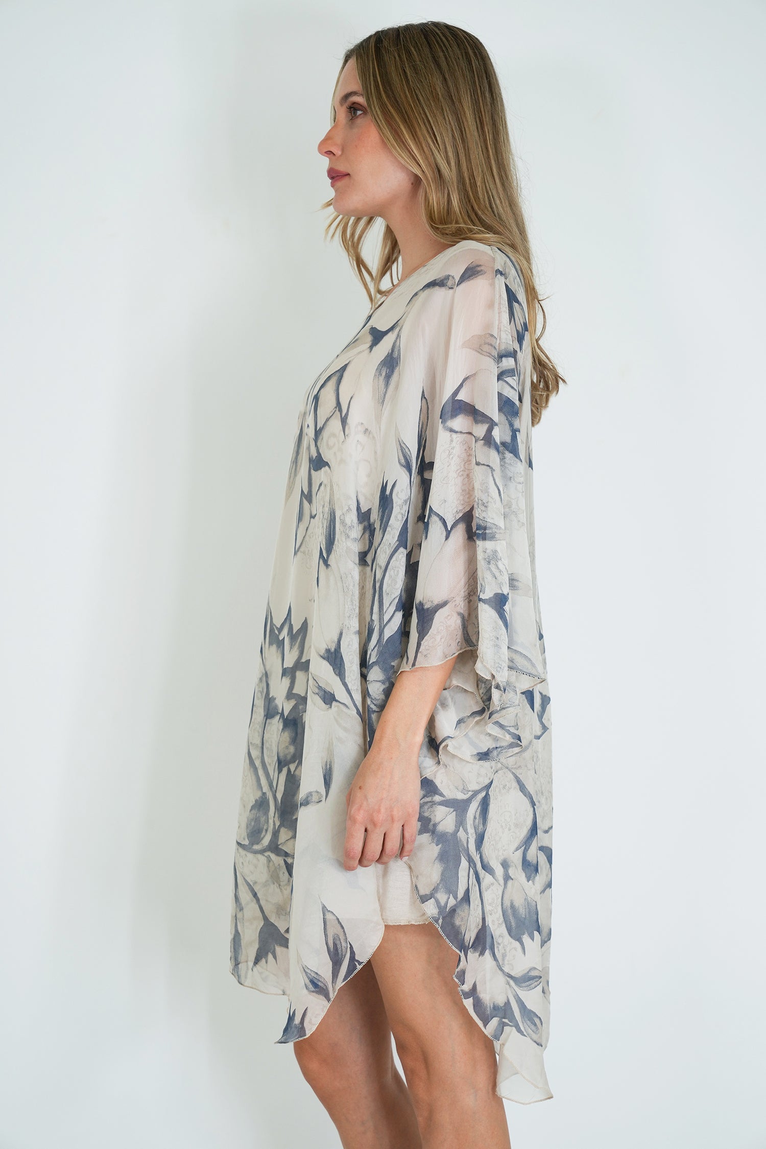 Woman wearing a floral kimono-style garment against a white background