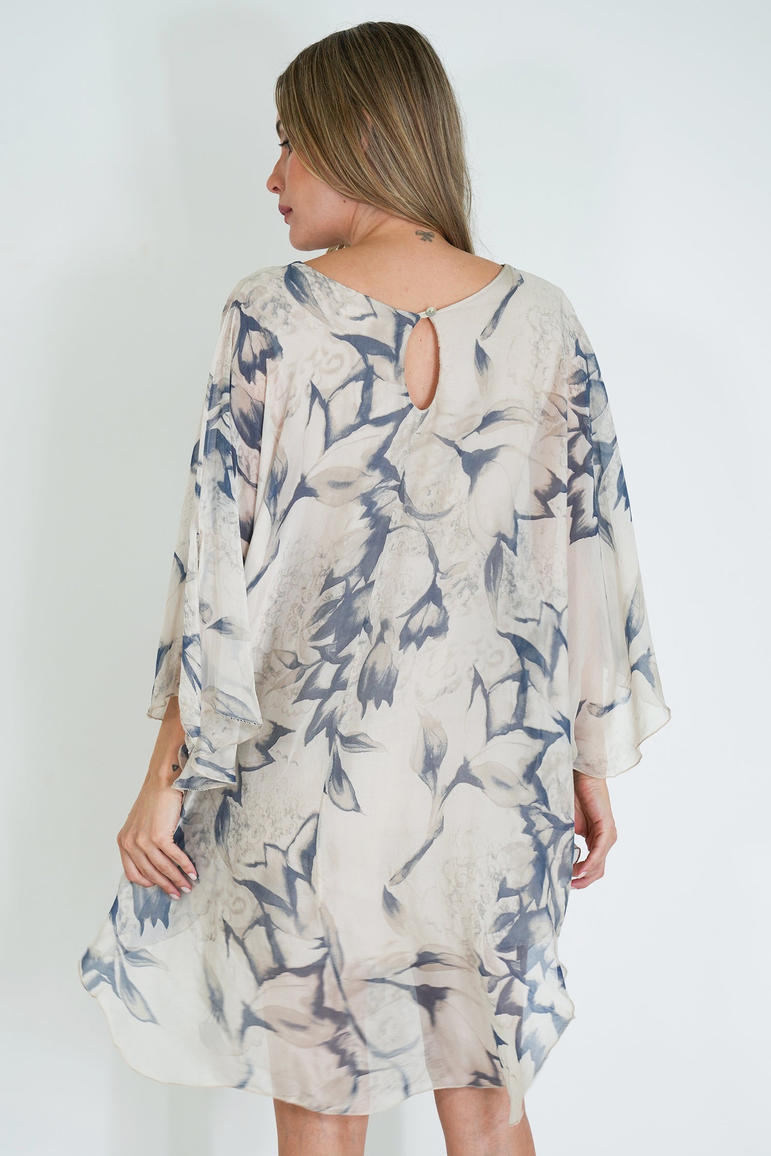 Woman wearing a floral patterned dress against a white background