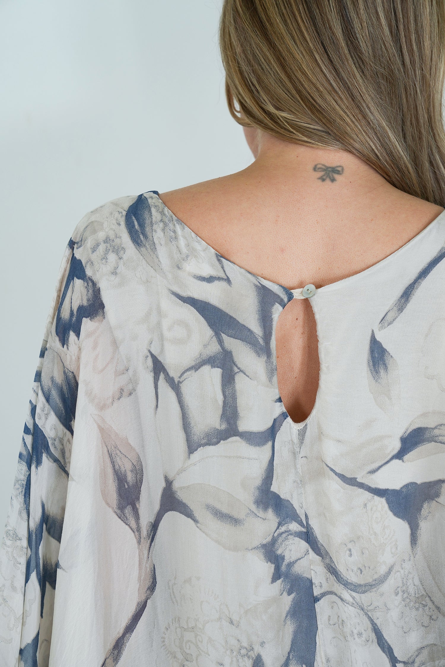 Floral patterned blouse with a cut-out back design.