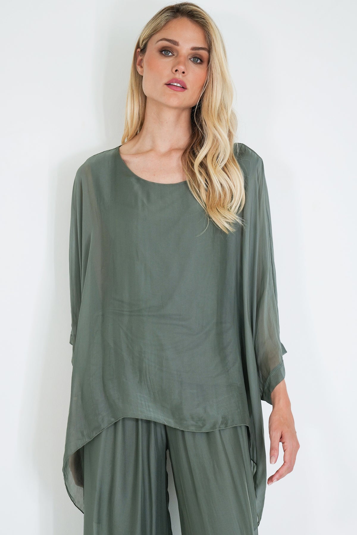 Woman wearing a green outfit against a white background