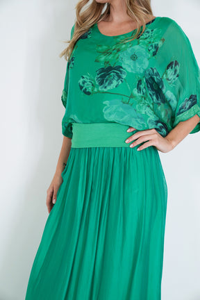 Woman wearing a green floral dress against a white background