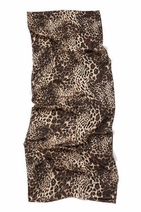 A leopard print scarf with a brown, black, and beige animal spot pattern, shown draped flat against a white background.