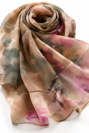 A lightweight silk scarf with an abstract watercolor pattern in muted shades of beige, brown, pink, and green, elegantly draped on a white background.