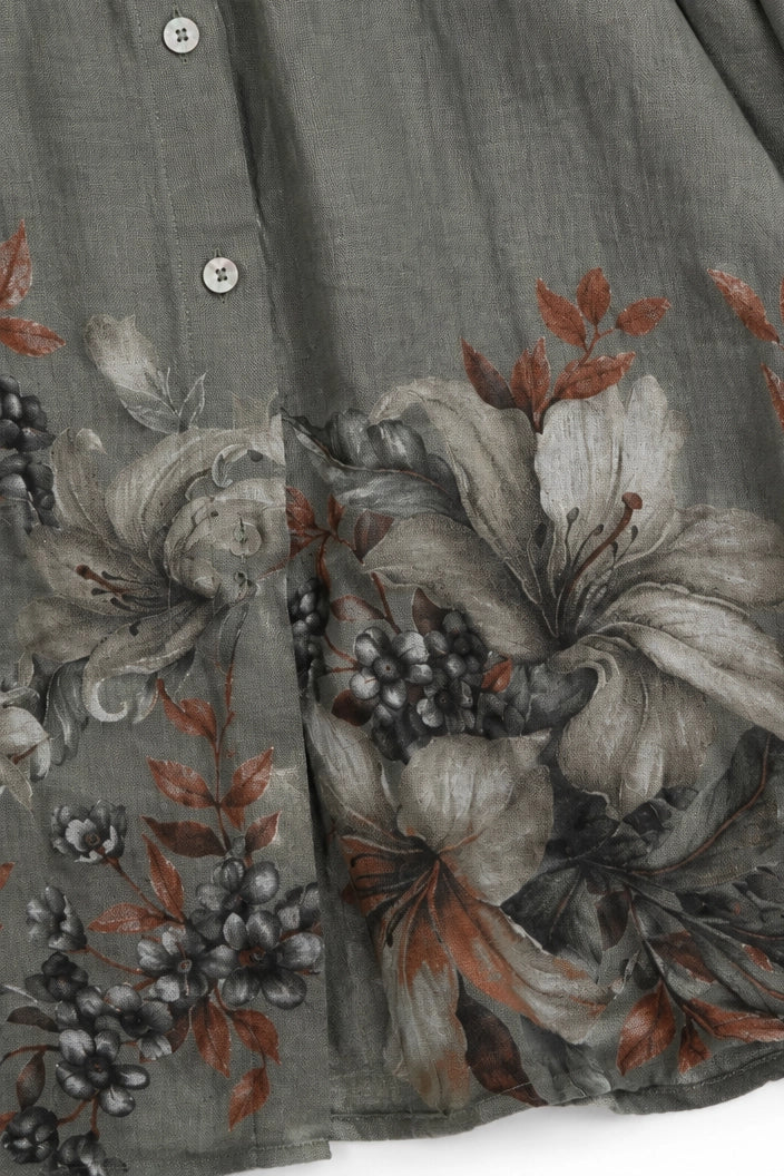 Close-up of a gray linen button-up shirt featuring a large floral print in gray, white, and rust brown tones.