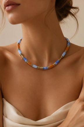 Necklace with blue and brown beads on a model against a beige background