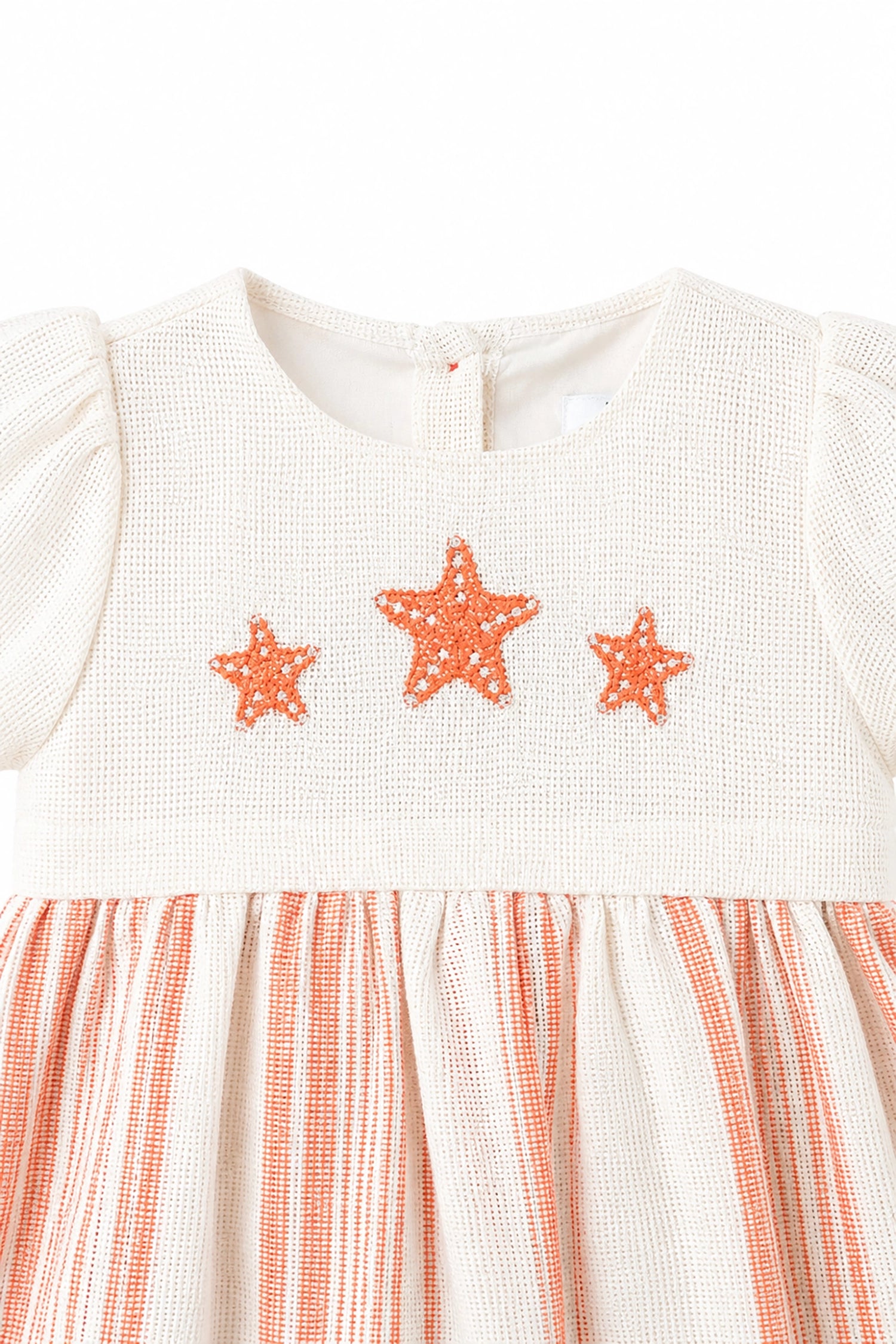 White dress with orange star patterns and striped skirt on a white background