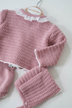A dusty pink knit set for a girl, consisting of a long-sleeved top with a round neckline and matching pants, displayed on a mannequin.