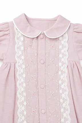 Pink dress with white lace details on a white background